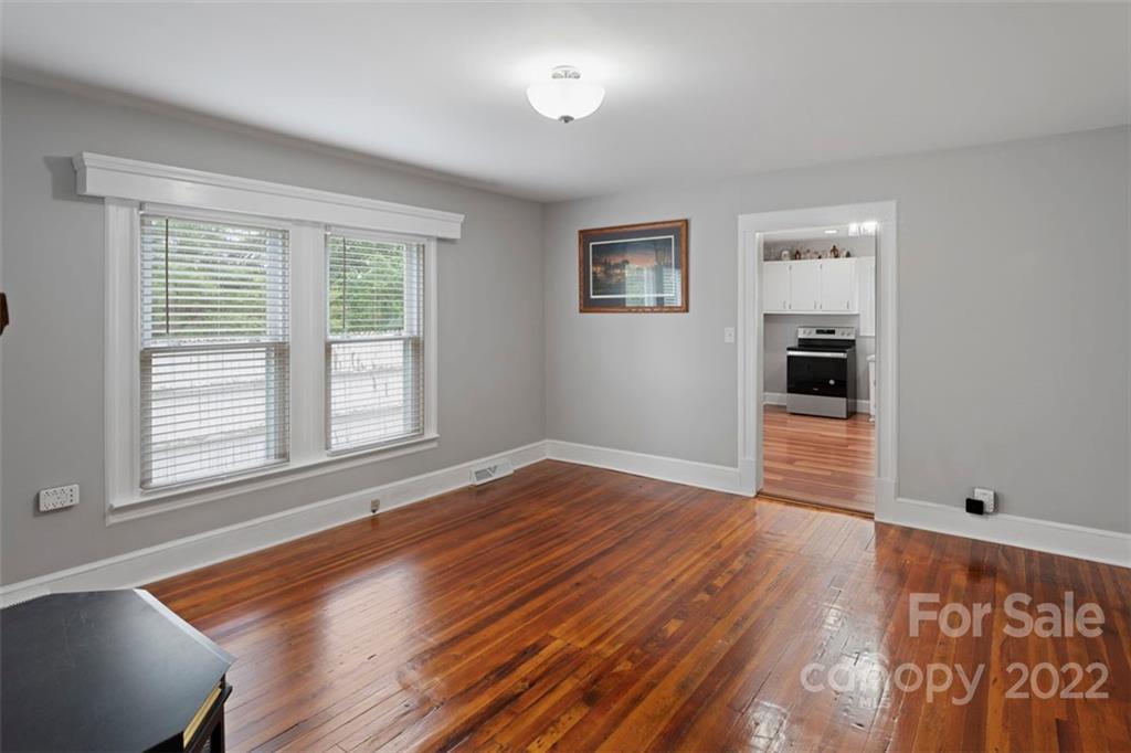 2139 Quaker Road Siloam, NC 27047 - Photo 22 of 35 a view of an empty room with wooden floor and a window
