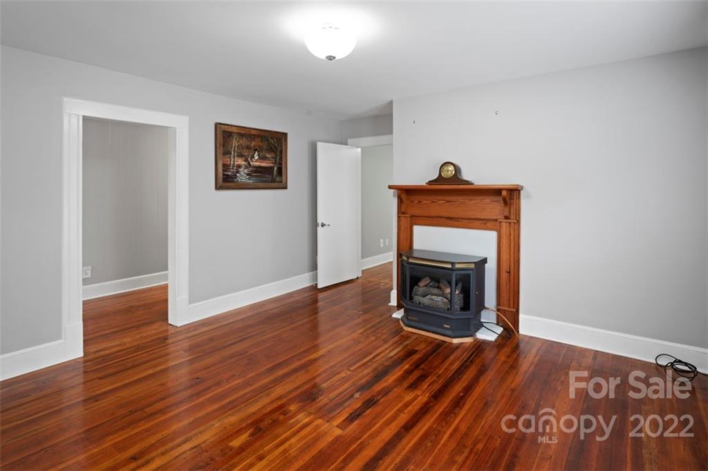 2139 Quaker Road Siloam, NC 27047 - Photo 24 of 35 a view of an empty room with wooden floor fire place