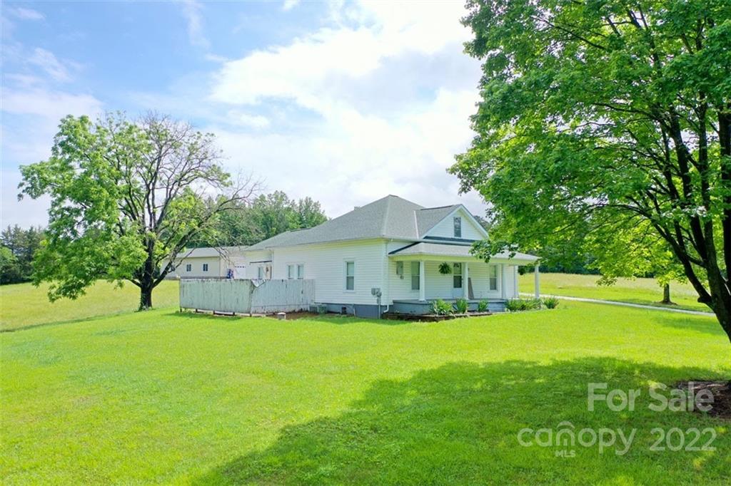 2139 Quaker Road Siloam, NC 27047 - Photo 5 of 35 a white house with a big yard and large trees