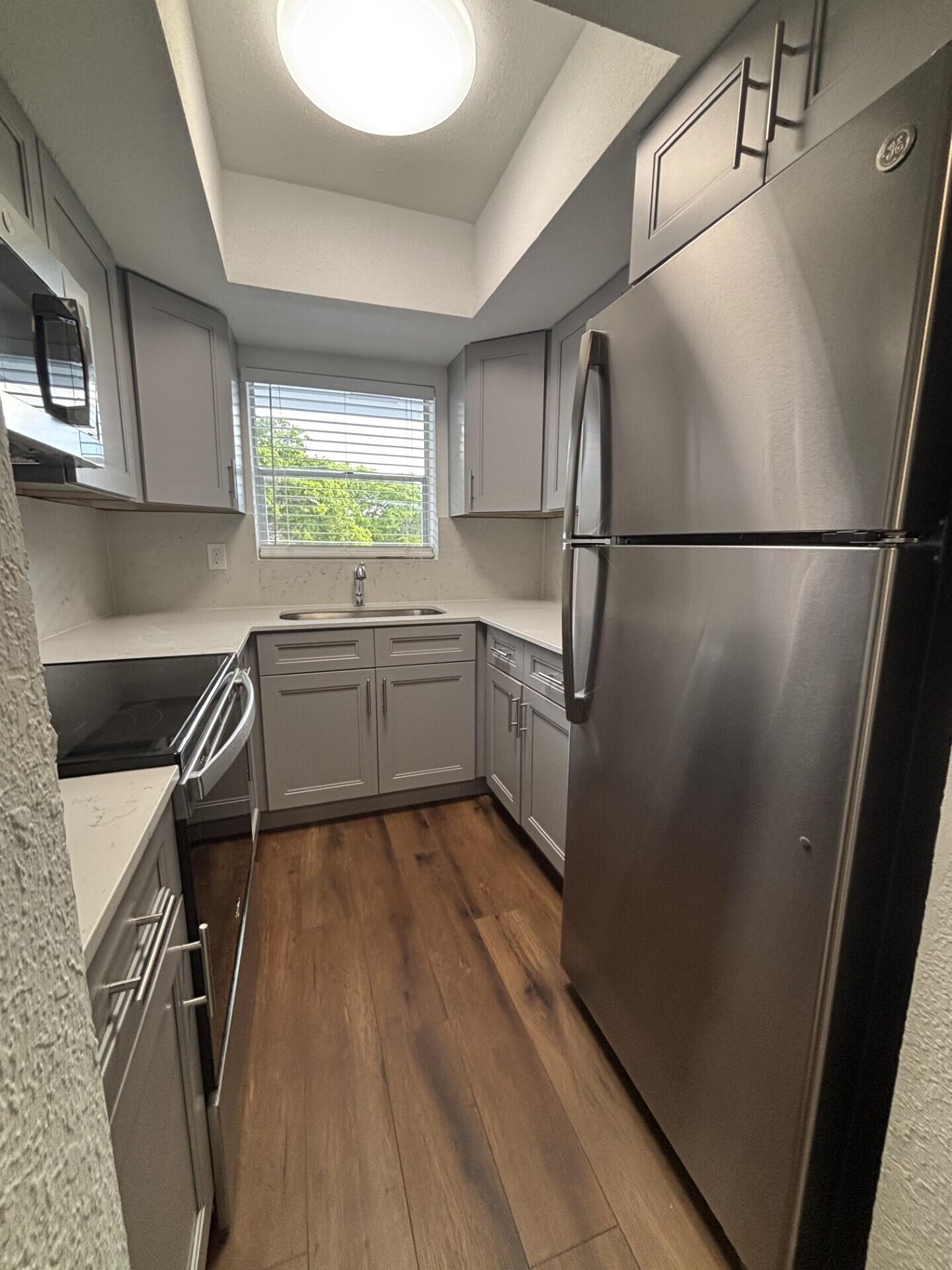 3510 Harrison Street, Unit 12 Hollywood, FL 33021 - Photo 12 of 18 a kitchen with a refrigerator a sink and cabinets