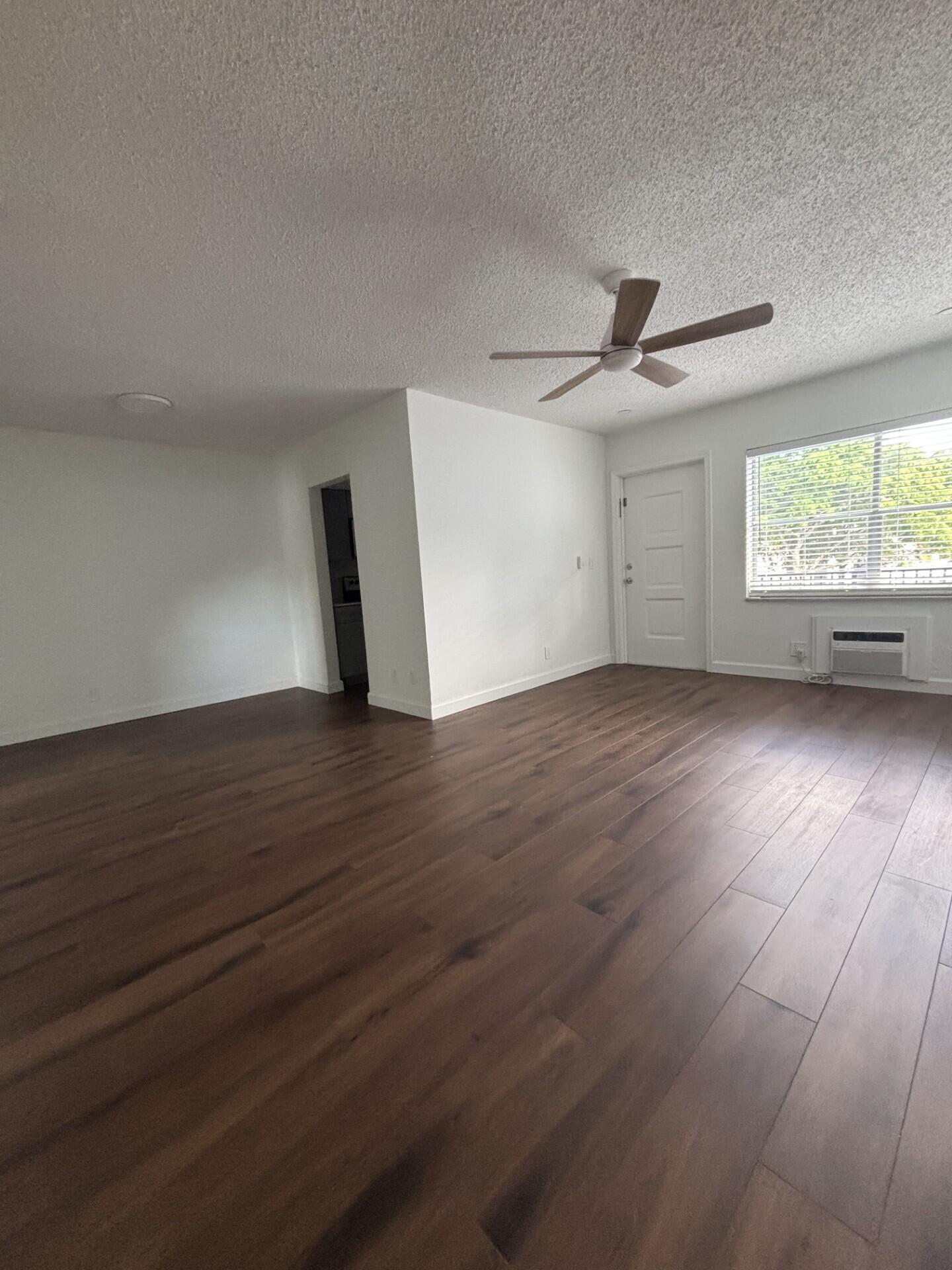 3510 Harrison Street, Unit 12 Hollywood, FL 33021 - Photo 14 of 18 an empty room with wooden floor and windows