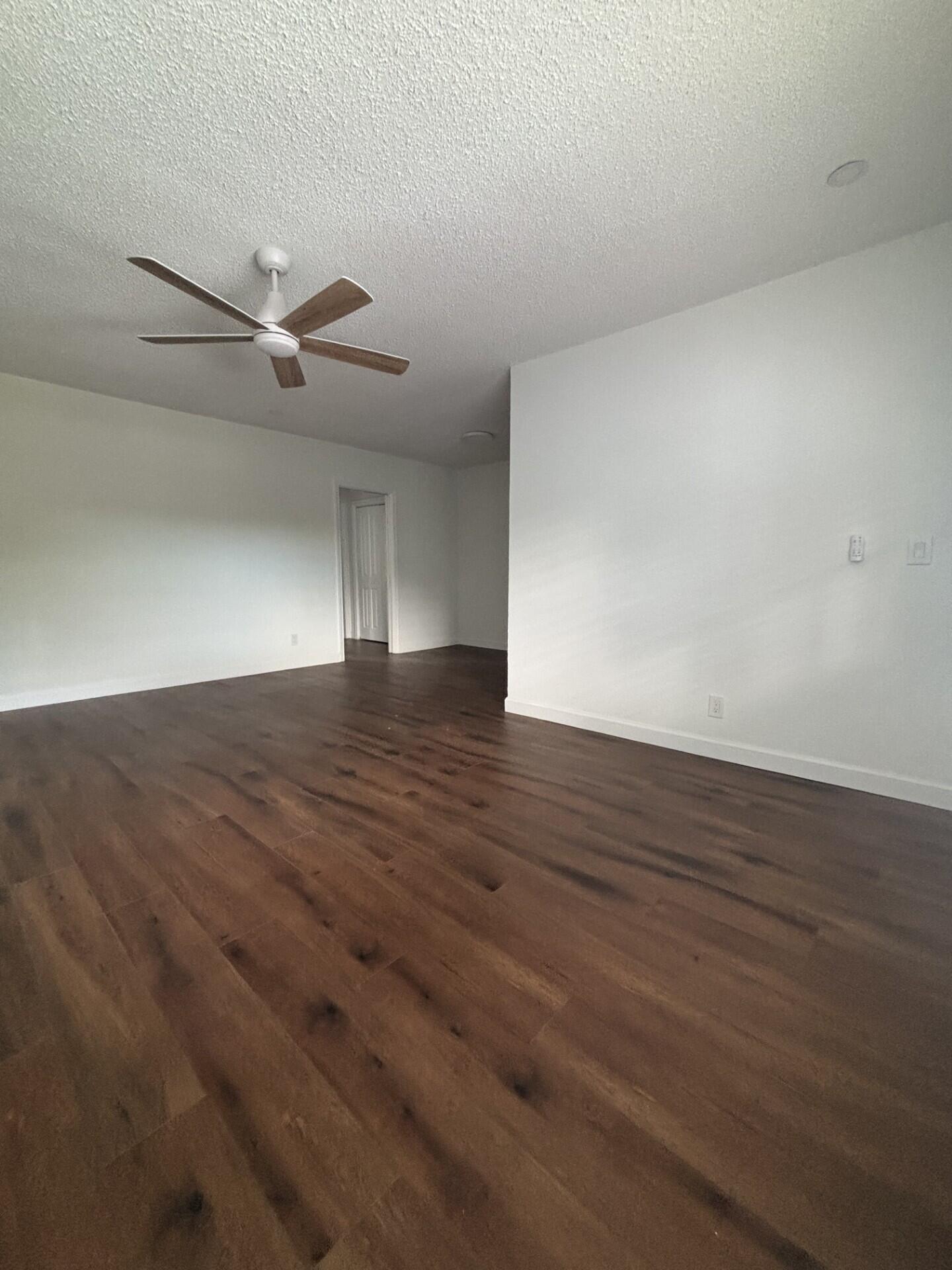3510 Harrison Street, Unit 12 Hollywood, FL 33021 - Photo 16 of 18 a view of empty room with wooden floor and ceiling fan