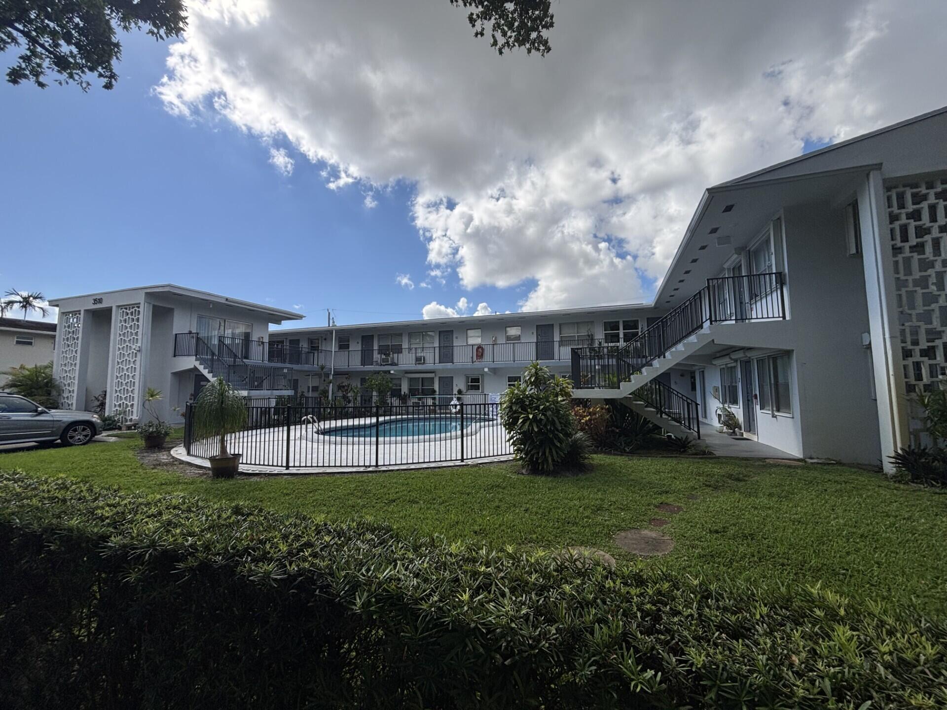 3510 Harrison Street, Unit 12 Hollywood, FL 33021 - Photo 2 of 18 a view of a house next to a yard with plants and large trees