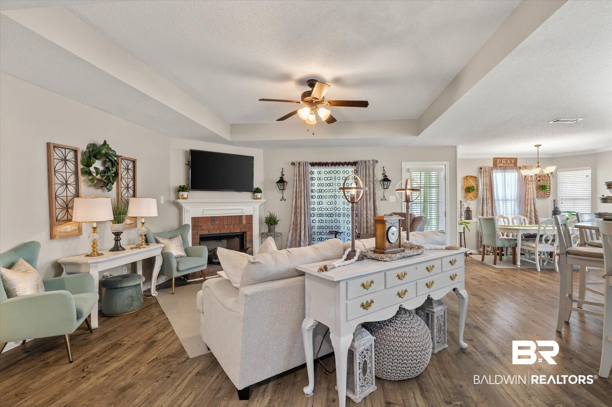 8600 Sable Court Semmes, AL 36575 - Photo 4 of 20 Living area with a raised ceiling, a fireplace, plenty of natural light, and a chandelier