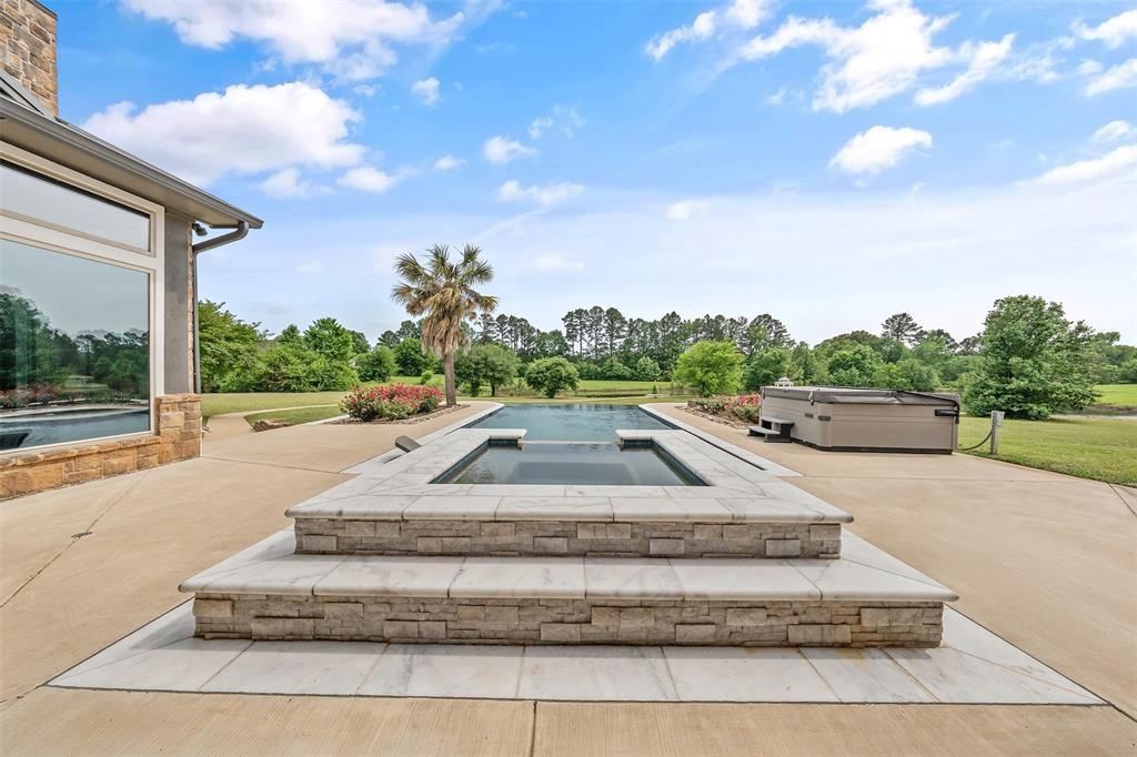 20389 County Road 178 Flint, TX 75762 - Photo 33 of 40 Outdoor patio featuring an integrated swimming pool and elevated spa, surrounded by concrete decking
