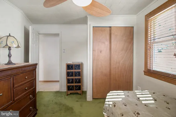 a view of a bedroom with a dresser and a window