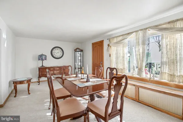 a dining room with furniture and a large window