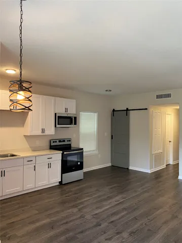 a kitchen with granite countertop a stove and a refrigerator