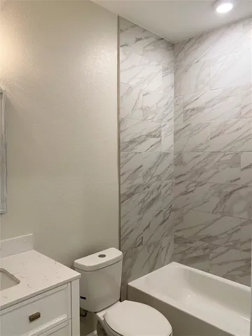 a white toilet sitting next to a shower