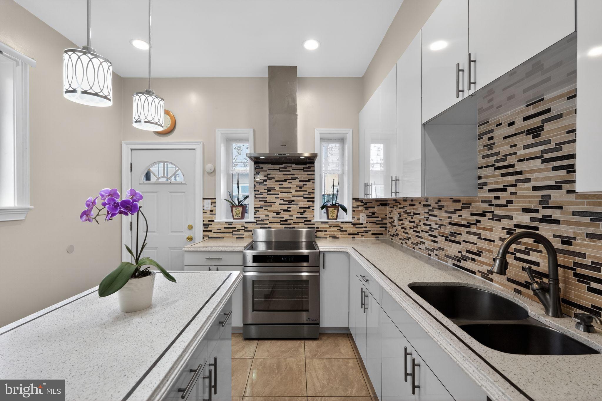 2515 South 16th Street Philadelphia, PA 19145 - Photo 11 of 29 a kitchen with a sink stove and cabinets