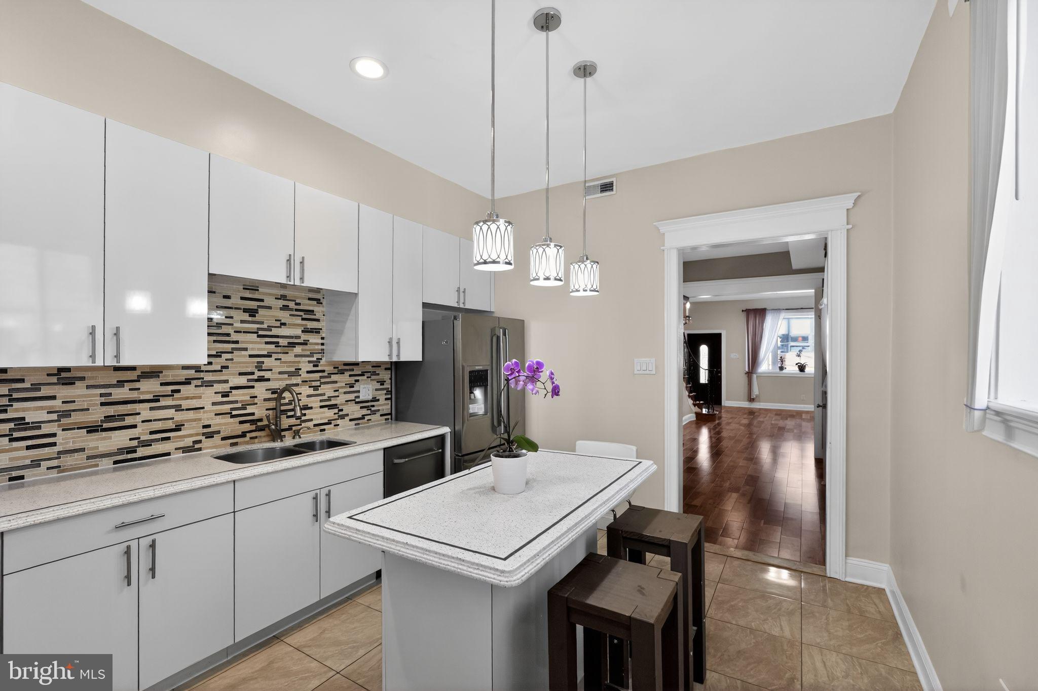 2515 South 16th Street Philadelphia, PA 19145 - Photo 10 of 29 a kitchen with kitchen island a counter space a sink appliances and cabinets
