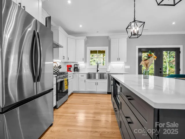 a kitchen with stainless steel appliances granite countertop a sink a stove and a refrigerator