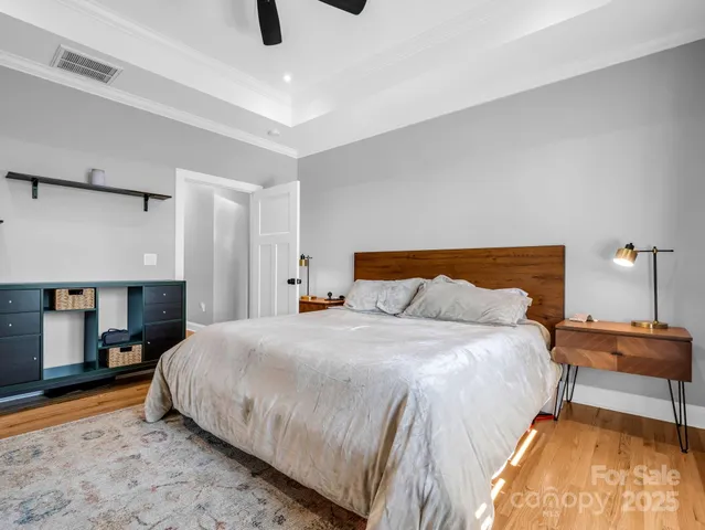 a bedroom with a bed and a lamp on the dresser