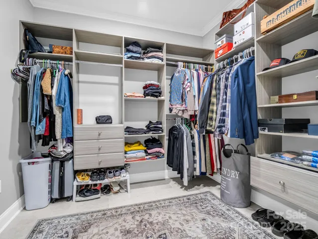 a view of walk in closet with clothes and shoes