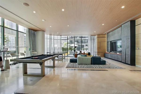 a living room with furniture a flat screen tv and a large window