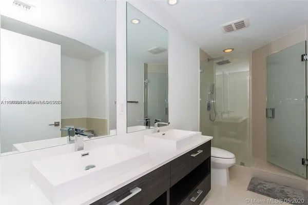a bathroom with a double vanity sink toilet and shower
