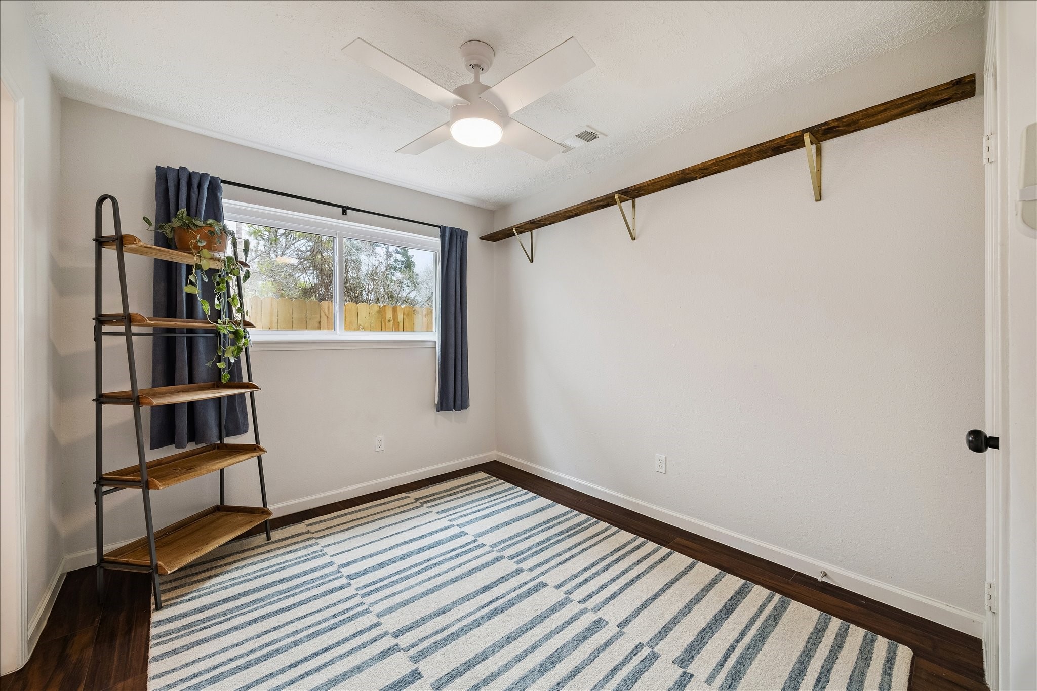 9707 Lawngate Drive Houston, TX 77080 - Photo 13 of 16 a view of empty room with wooden floor and fan