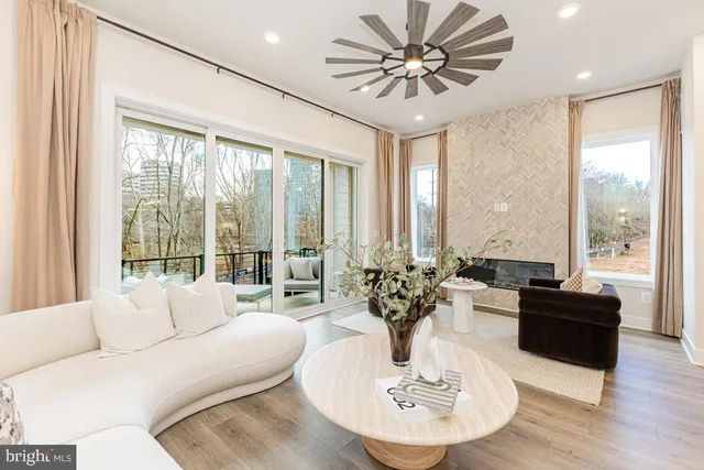 a living room with furniture potted plant and a large window