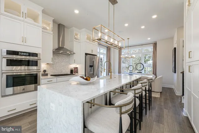 a kitchen with stainless steel appliances kitchen island a large island in the center and cabinets