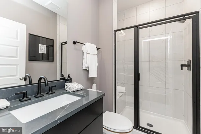 a bathroom with a sink toilet double vanity and shower