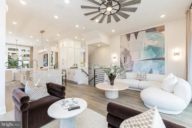 a living room with furniture kitchen view and a chandelier