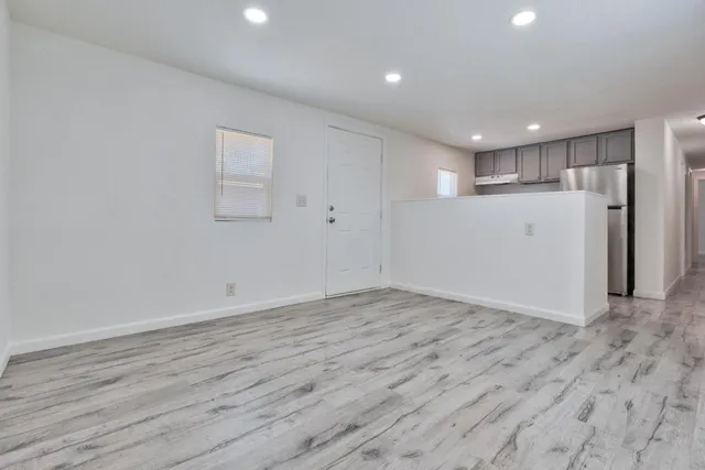 a view of empty room with wooden floor