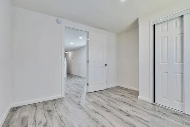 a view of an empty room with wooden floor