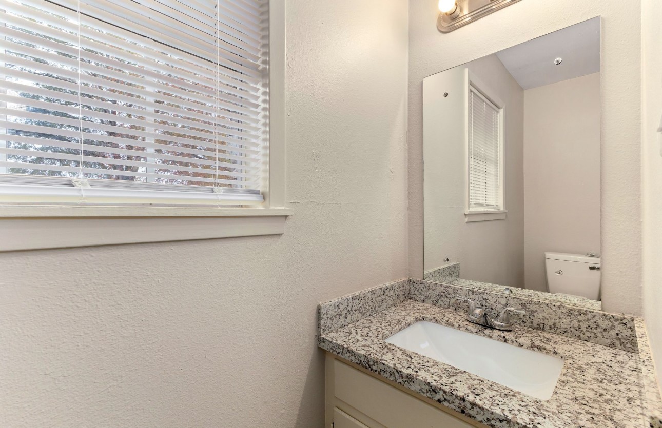 1609 Longhofer Street Brenham, TX 77833 - Photo 18 of 18 a bathroom with a granite countertop sink and a mirror
