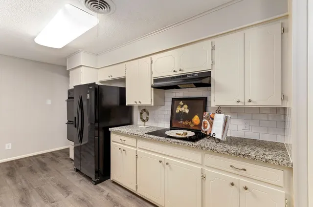 a kitchen with granite countertop a refrigerator stove and microwave