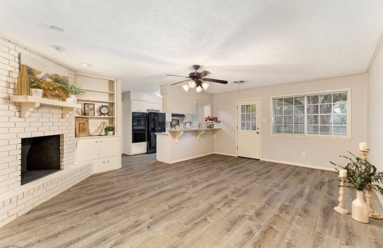 1609 Longhofer Street Brenham, TX 77833 - Photo 9 of 18 a view of a livingroom with a fireplace wooden floor and windows