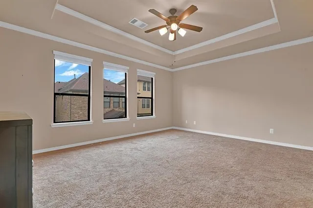 an empty room with windows and chandelier fan