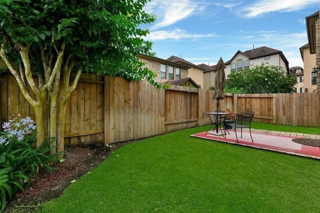 a view of a backyard with table and chairs and wooden fence