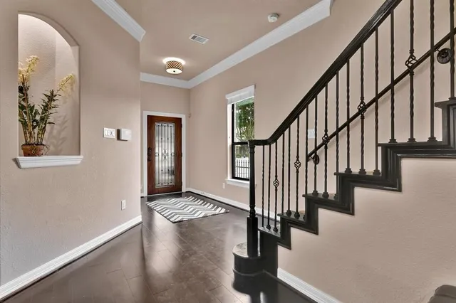 a view of staircase with wooden floor and frames on wall