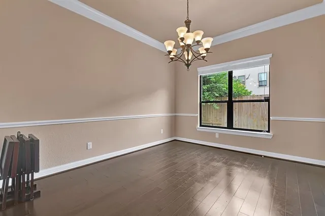 a view of wooden floor in an empty room with a window