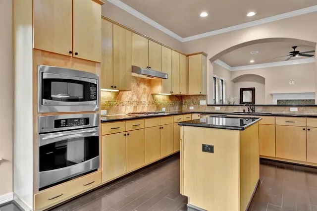 a kitchen with stainless steel appliances granite countertop a stove a sink and a microwave