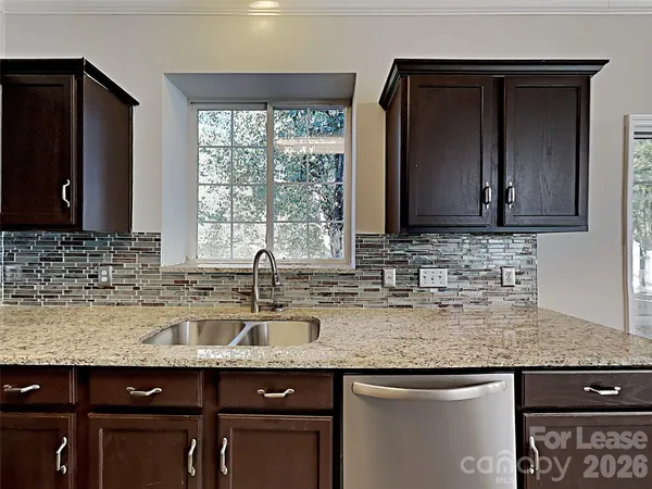 a kitchen with granite countertop a sink and a wooden cabinets