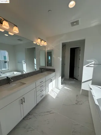 a spacious bathroom with a double vanity sink and a mirror
