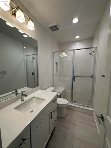 a bathroom with a double vanity sink toilet and shower