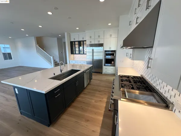 a kitchen with kitchen island sink stove and refrigerator