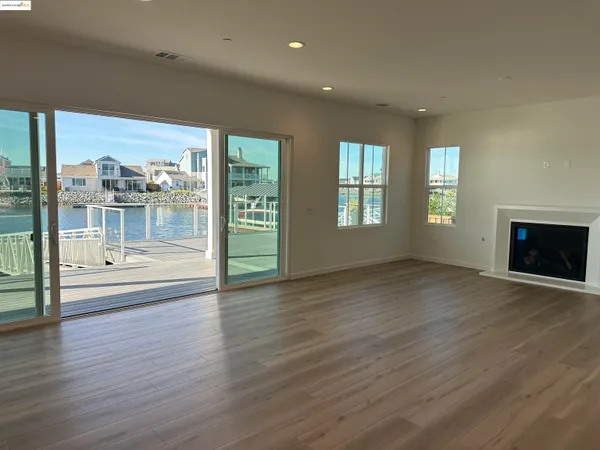 an empty room with wooden floor and fireplace