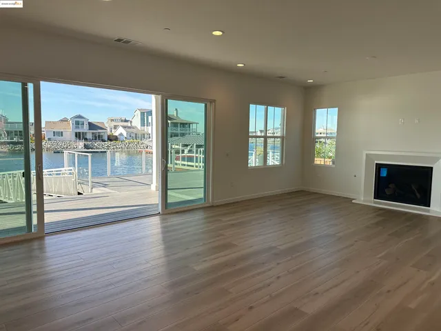 an empty room with wooden floor and fireplace