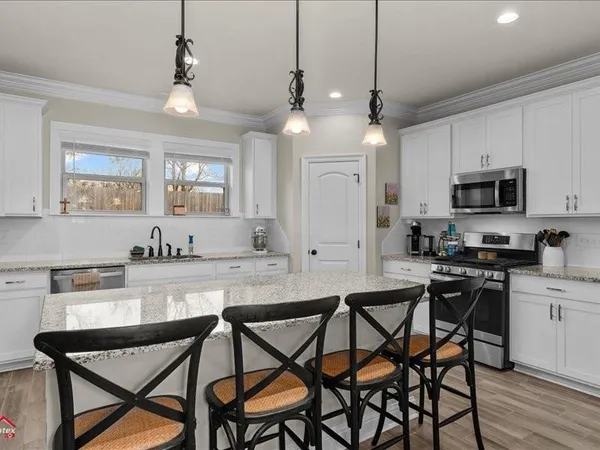 a kitchen with a dining table chairs sink and cabinets
