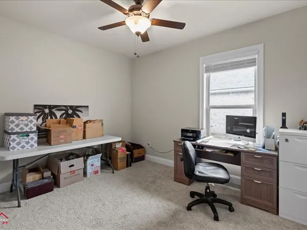 a view of a workspace with furniture and a window