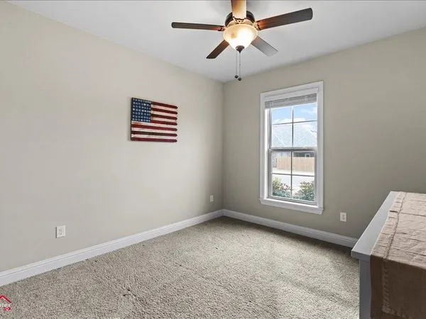 an empty room with windows and fan