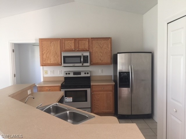 3608 13th Street Southwest Lehigh Acres, FL 33976 - Photo 2 of 11 a kitchen with a refrigerator sink and microwave