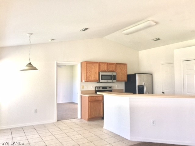 3608 13th Street Southwest Lehigh Acres, FL 33976 - Photo 3 of 11 a kitchen with stainless steel appliances kitchen island granite countertop a refrigerator and a stove top oven
