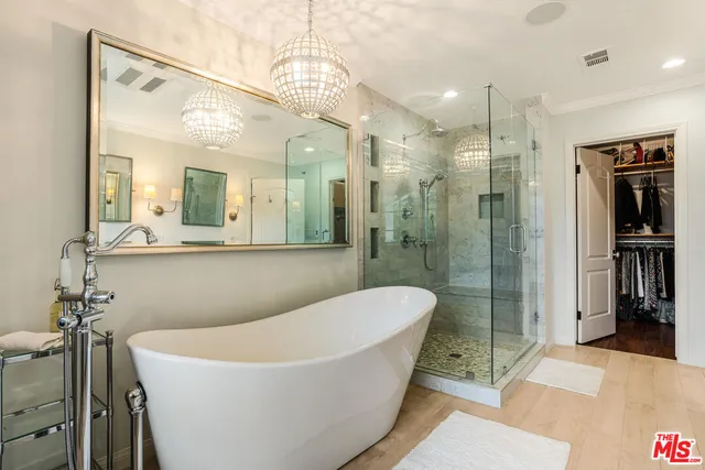 a bathroom with a bathtub a mirror a shower and vanity