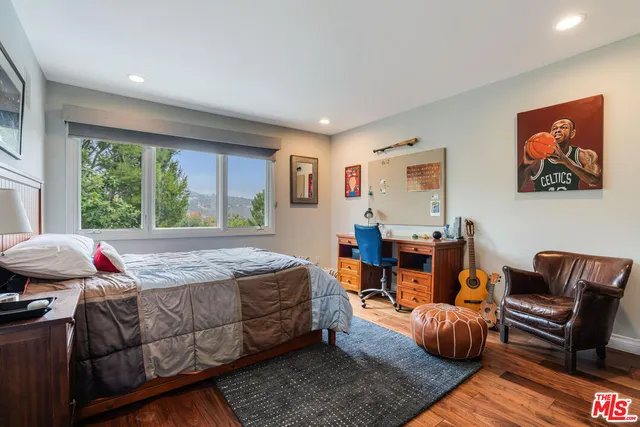 a bedroom with furniture and a large window