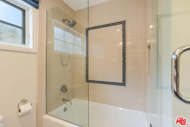 a bathroom with a shower and a bath tub
