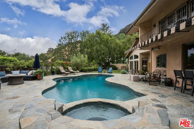 a view of a swimming pool with chairs in patio